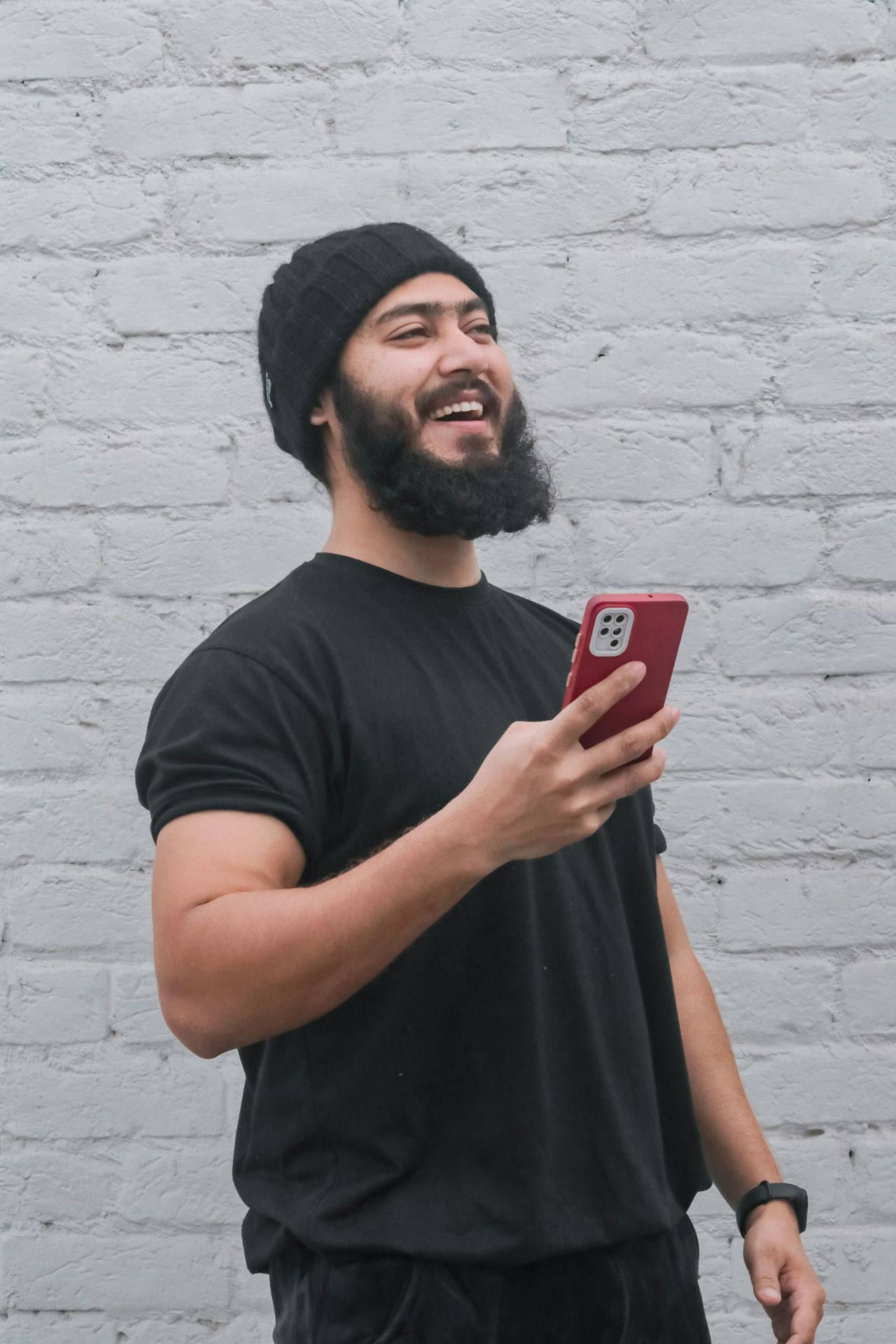a man with a beard holding a cell phone